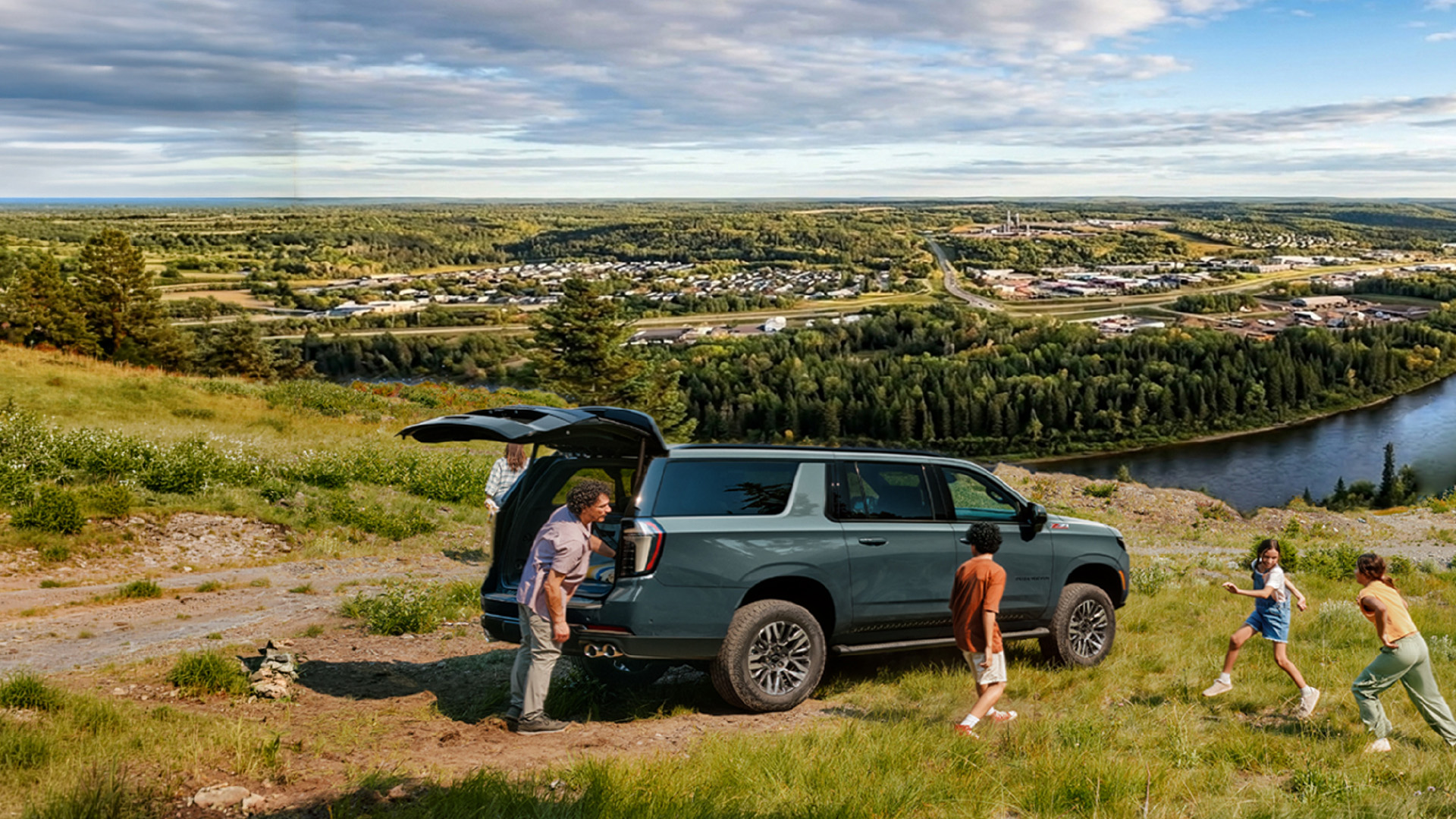 2026_WBAF_WebsitePhotos-01 Family enjoying Wood Buffalo National Park in summer outdoors surrounding an off-road trim of Chevrolet Tahoe in teal colour